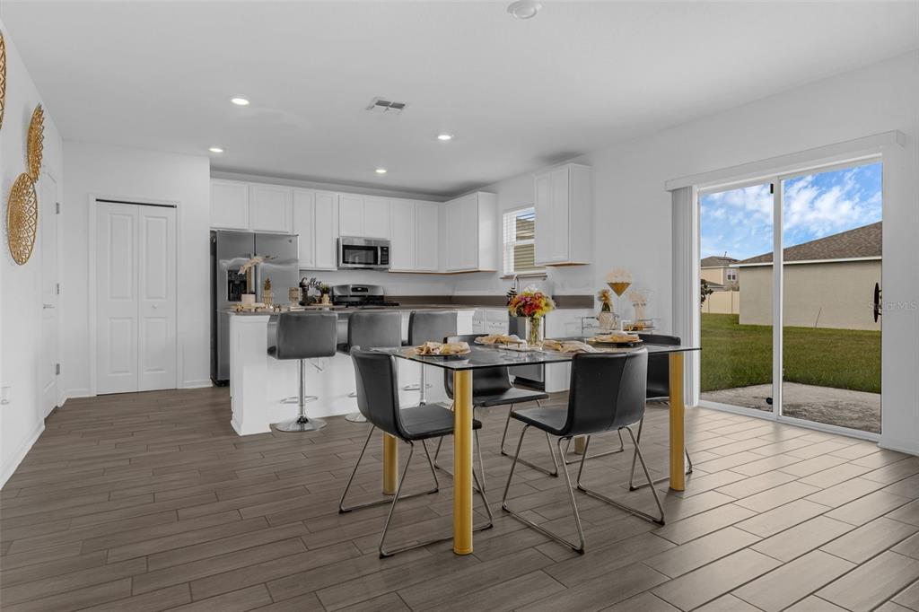 34535 Shellback Street Leesburg, FL 34788 - Photo 11 of 36 a living room with stainless steel appliances kitchen island granite countertop furniture and a wooden floor