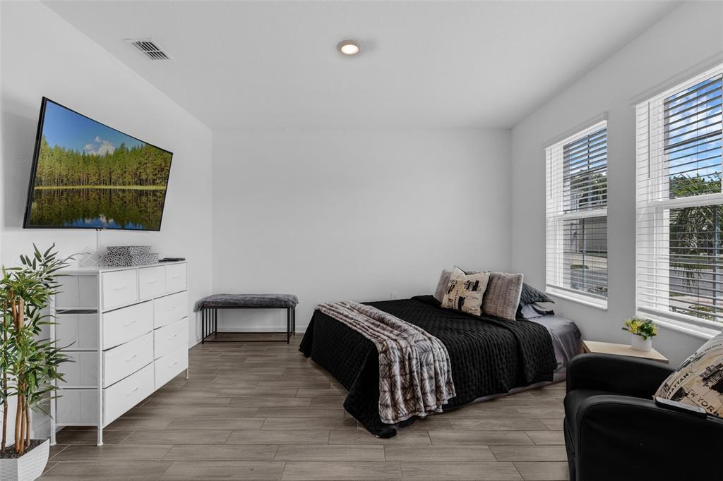 34535 Shellback Street Leesburg, FL 34788 - Photo 29 of 36 a bedroom with a bed and a flat screen tv