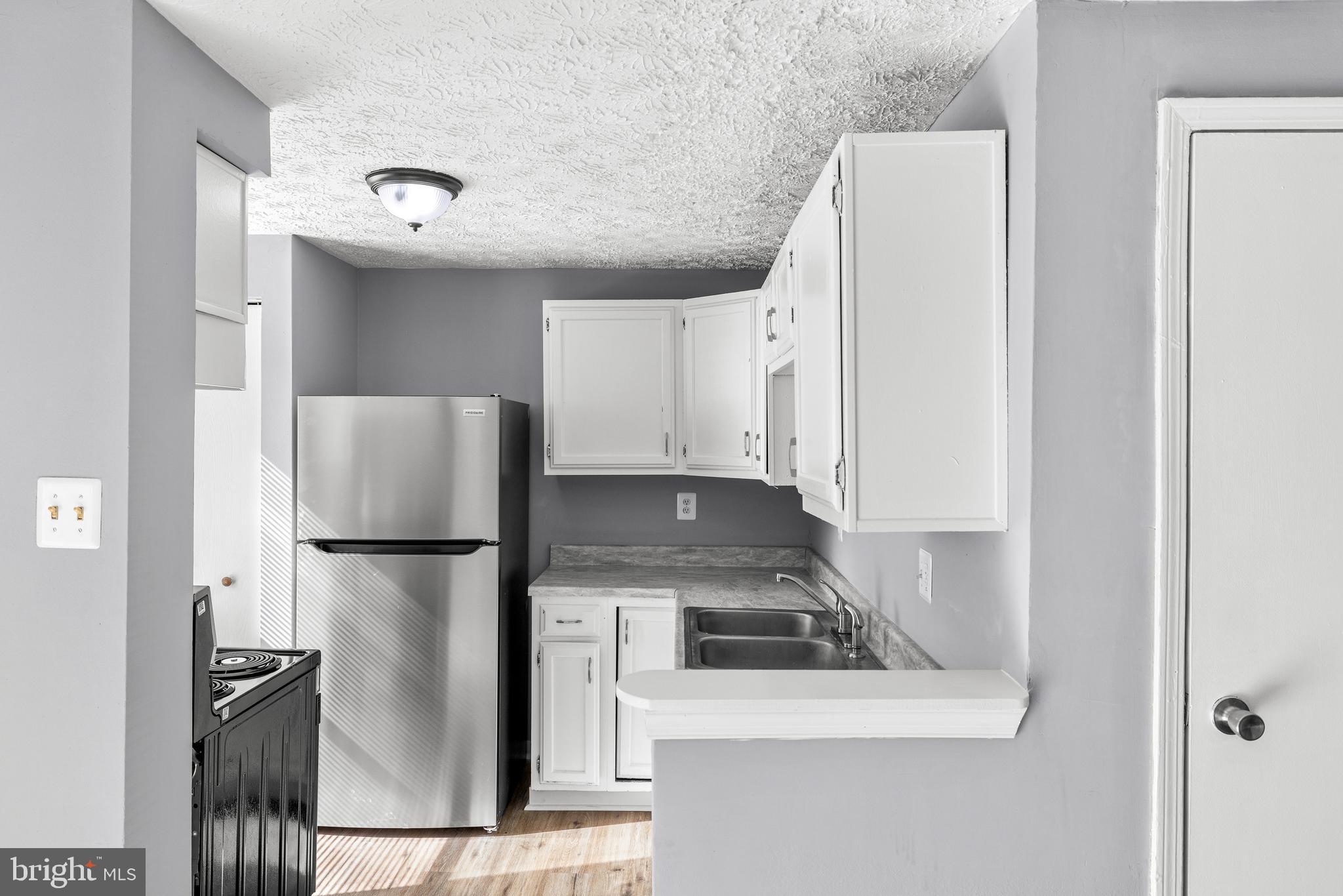 9479 Inaugural Drive King George, VA 22485 - Photo 8 of 26 a kitchen with a refrigerator sink stove and cabinets