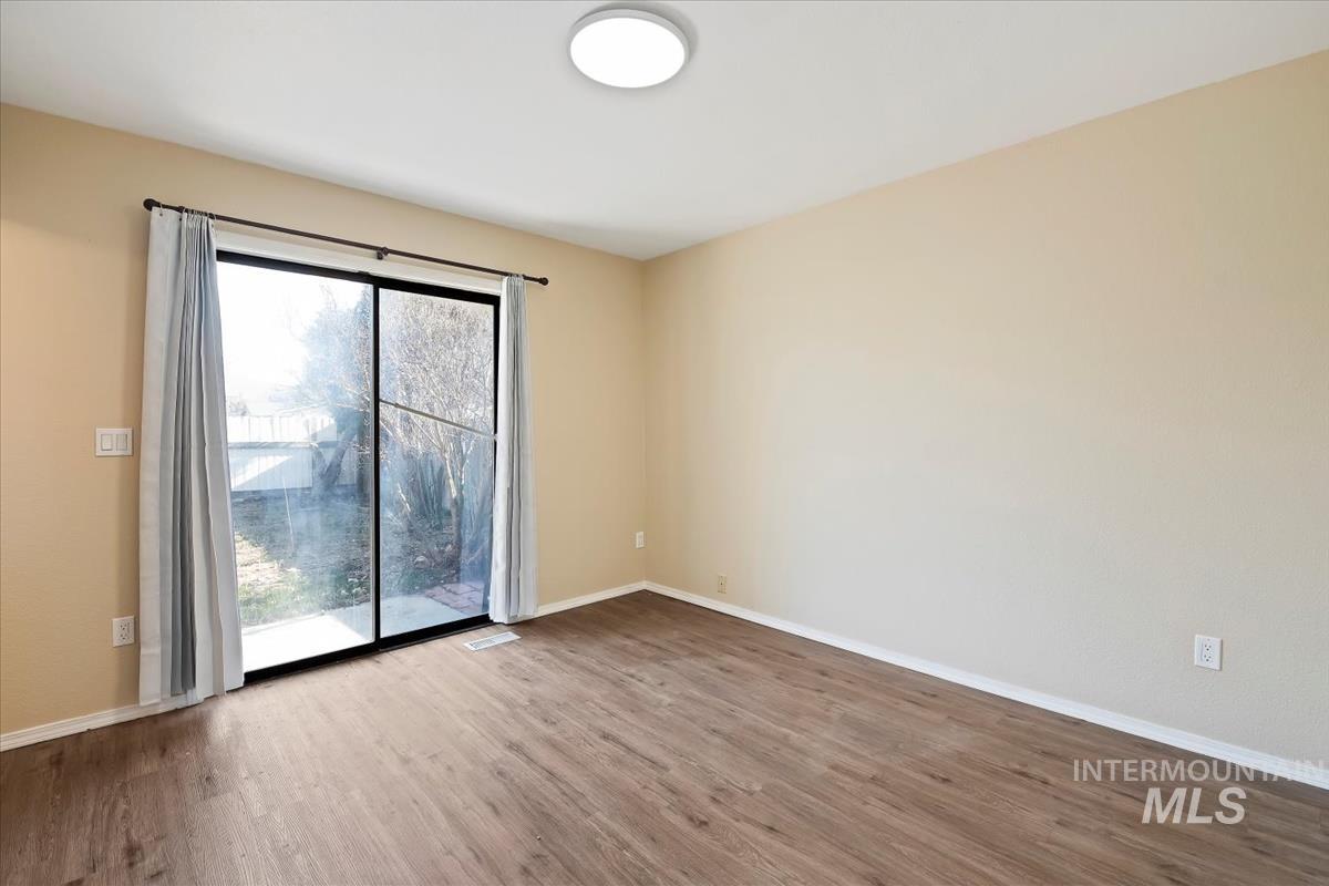7091 West Limelight Street Boise, ID 83714 - Photo 18 of 34 Master Bedroom featuring light wood-style floors and sliding doors to patio.