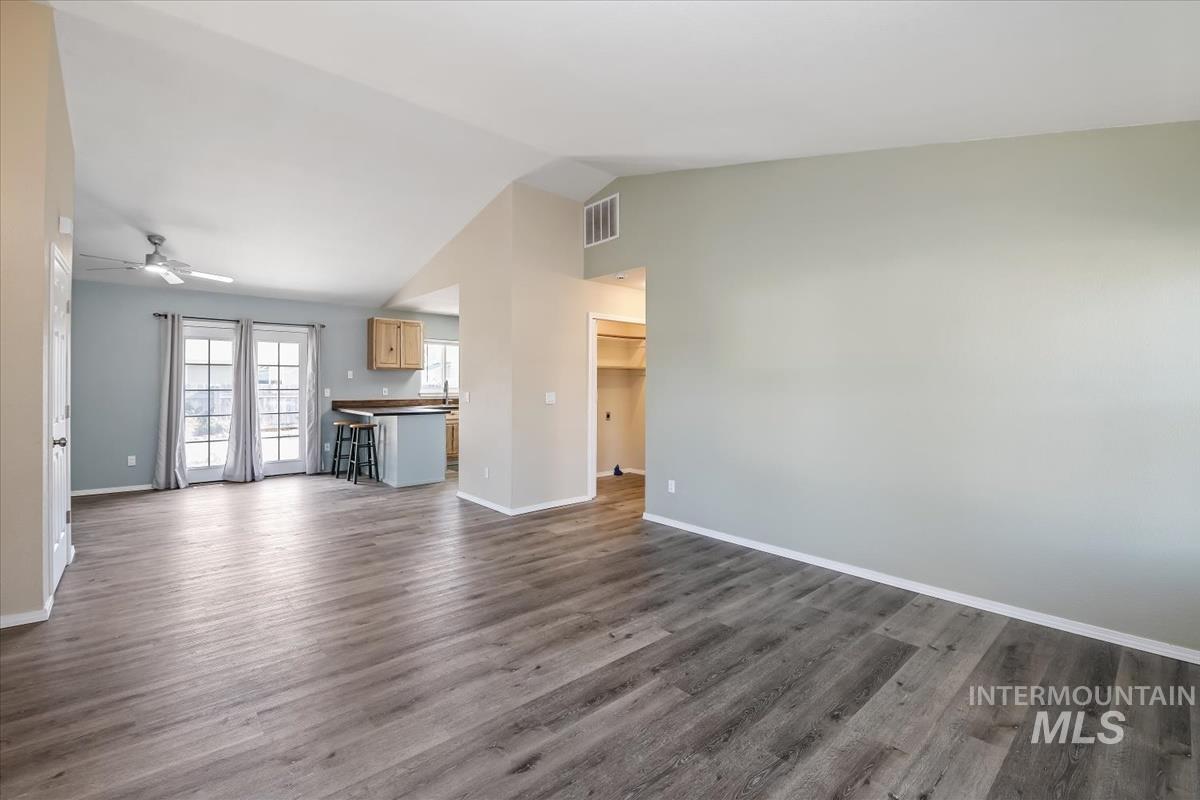 7091 West Limelight Street Boise, ID 83714 - Photo 4 of 34 Unfurnished living room featuring lofted ceiling, a ceiling fan, and dark wood finished floors