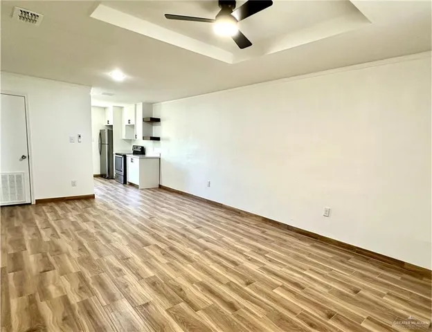 a view of empty room with wooden floor