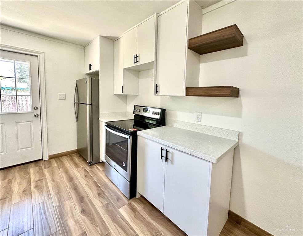 2714 West Mile 17 1/2 Road, Unit 23 Edinburg, TX 78541 - Photo 4 of 14 a kitchen with a refrigerator and a stove top oven