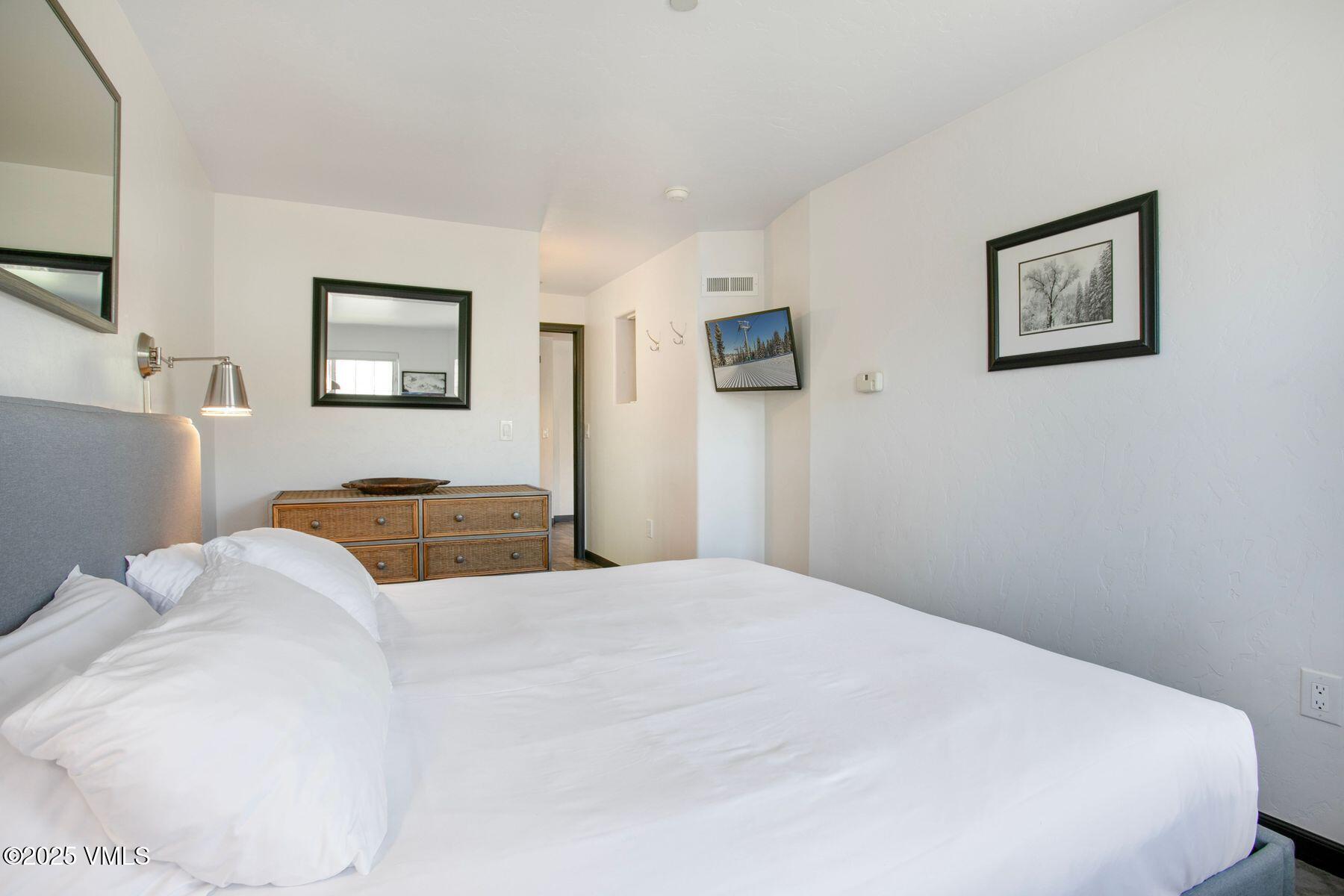 97 Main Street, Unit 304 Edwards, CO 81632 - Photo 14 of 31 a bedroom with a bed and a painting on the wall
