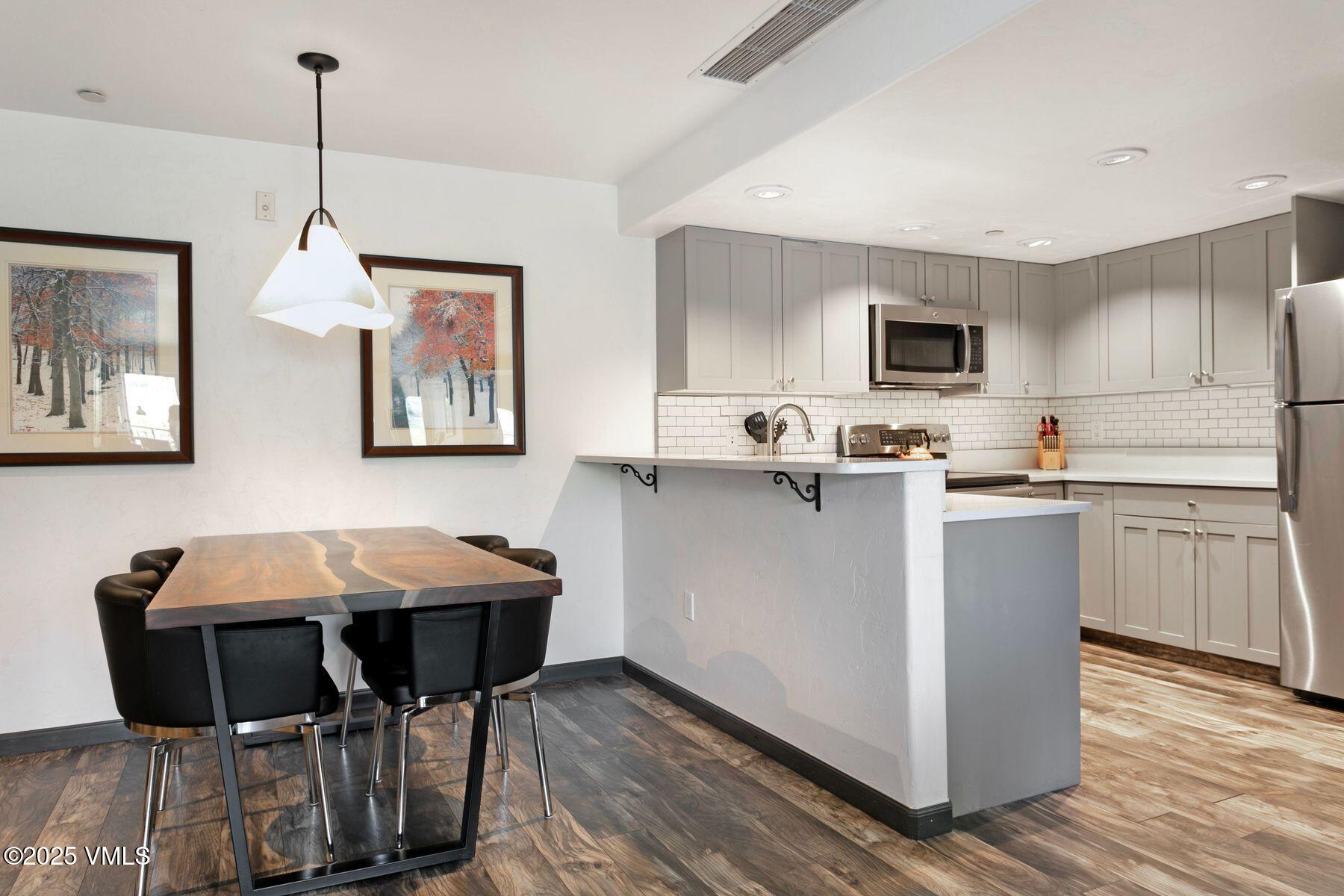 97 Main Street, Unit 304 Edwards, CO 81632 - Photo 8 of 31 a kitchen with a table chairs refrigerator and cabinets