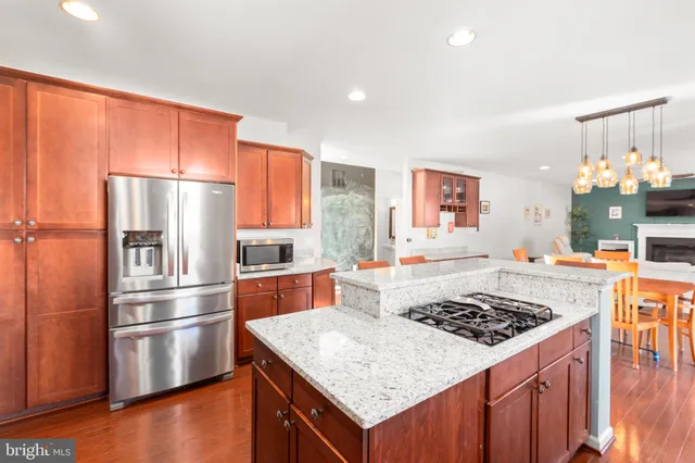 a kitchen with stainless steel appliances granite countertop wooden cabinets and a stove top oven