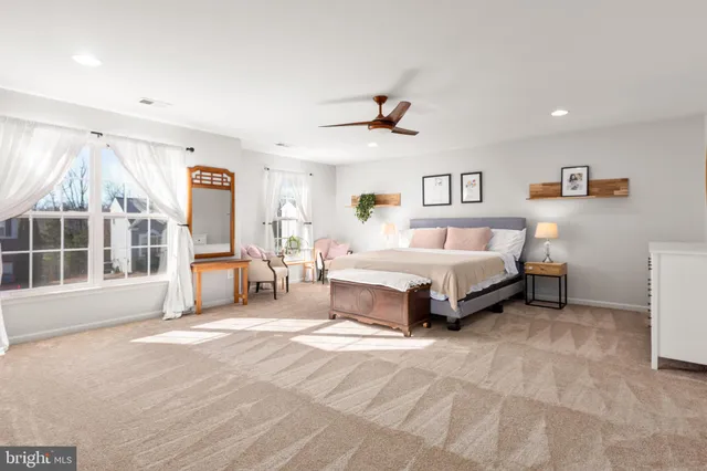 a spacious bedroom with a bed a window and a chandelier