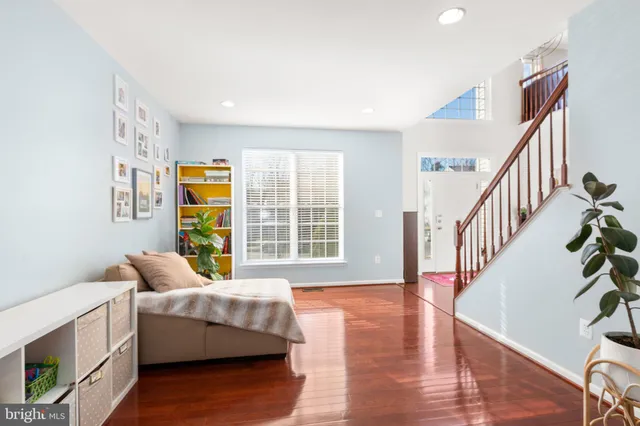 a dining room with wooden floor a chandelier a wooden table and chairs