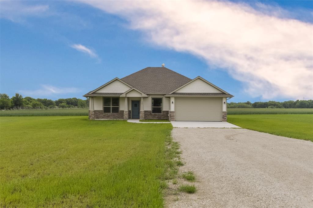 a front view of a house with a yard and lake view