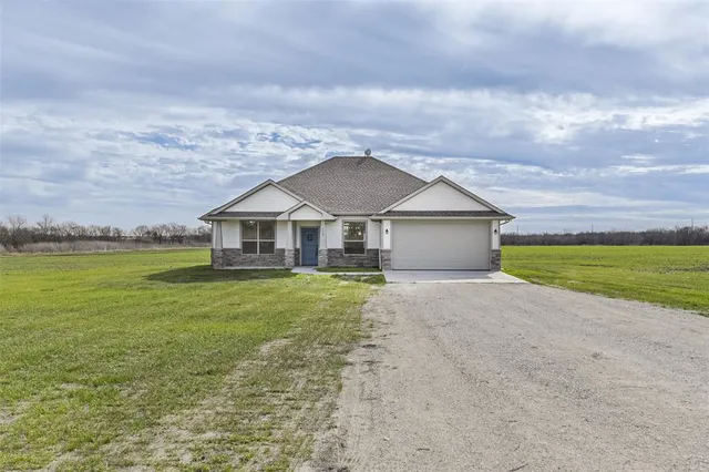 a front view of house with yard and garage