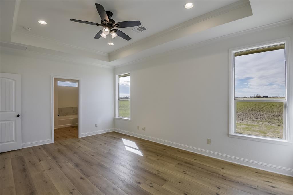 138 Zmolek Road Alma, TX 75119 - Photo 17 of 29 an empty room with wooden floor chandelier fan and windows