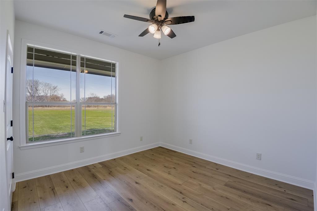 138 Zmolek Road Alma, TX 75119 - Photo 21 of 29 an empty room with a window and a ceiling fan
