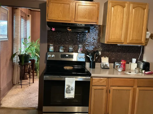 a kitchen with stainless steel appliances granite countertop a stove a sink and a microwave