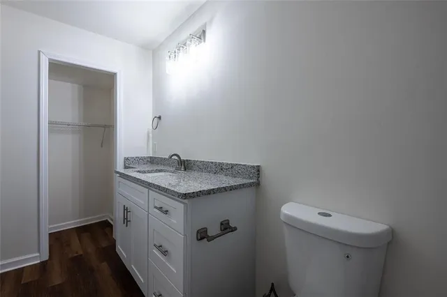 a bathroom with a granite countertop sink and a toilet