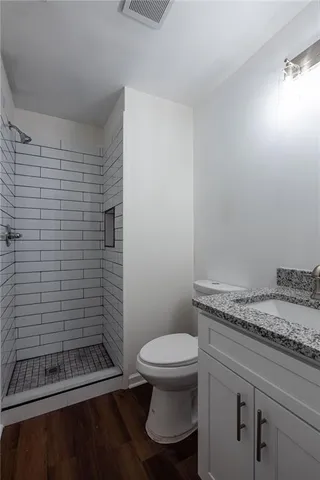 a bathroom with a granite countertop toilet and a sink