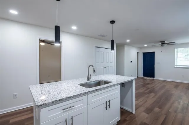 a kitchen with center island a sink appliances and a counter top space