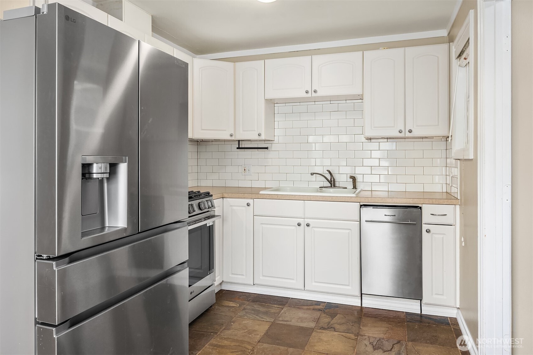 6741 34th Avenue Southwest Seattle, WA 98126 - Photo 5 of 25 a kitchen with stainless steel appliances granite countertop a refrigerator sink and white cabinets