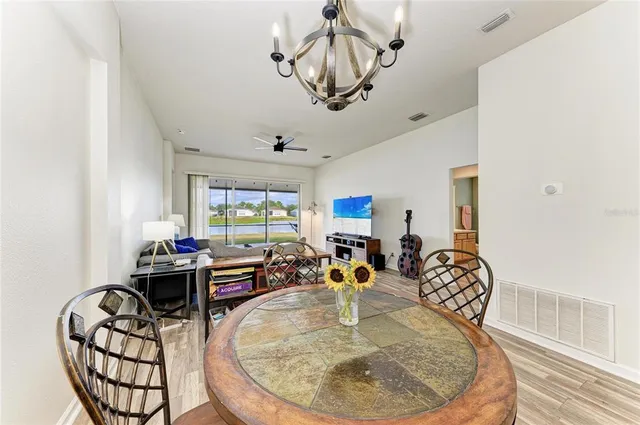 a dining room with furniture a chandelier and wooden floor