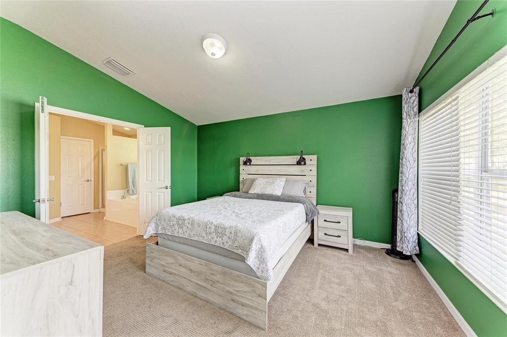 9950 52nd Street East Parrish, FL 34219 - Photo 24 of 48 a spacious bedroom with a bed and a window