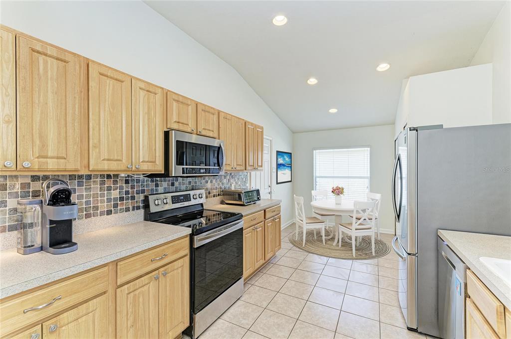 9950 52nd Street East Parrish, FL 34219 - Photo 8 of 48 a kitchen with a sink a stove and a refrigerator