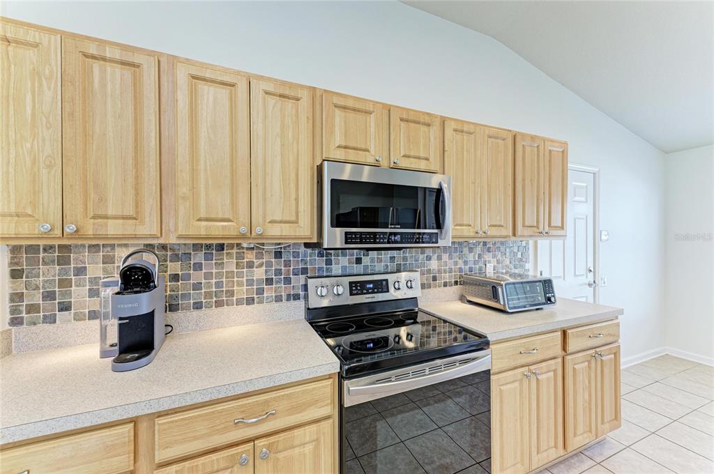 9950 52nd Street East Parrish, FL 34219 - Photo 9 of 48 a kitchen with stainless steel appliances granite countertop a sink stove and microwave