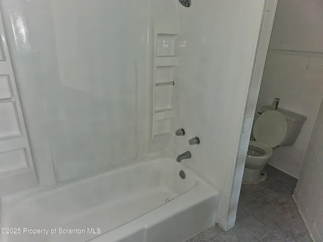 a bath room with a toilet and a bath tub