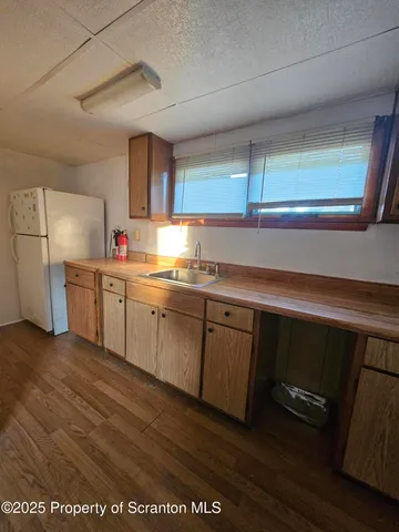a kitchen with a sink cabinets and wooden floor