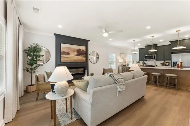 a living room with furniture kitchen view and a potted plant