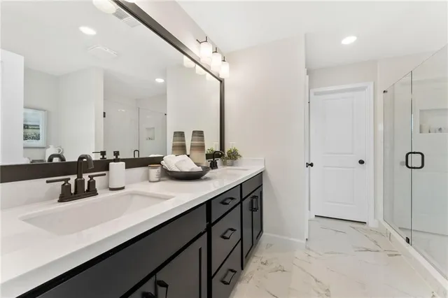 a bathroom with a double vanity sink a mirror and shower