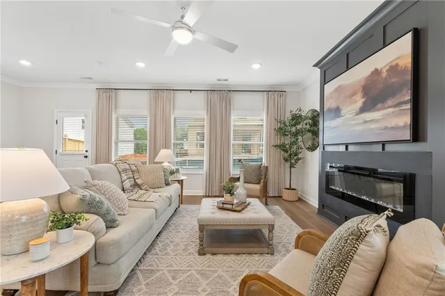 a living room with furniture ceiling fan and a flat screen tv