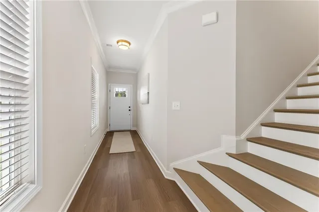 a view of a hallway with wooden floor and entryway