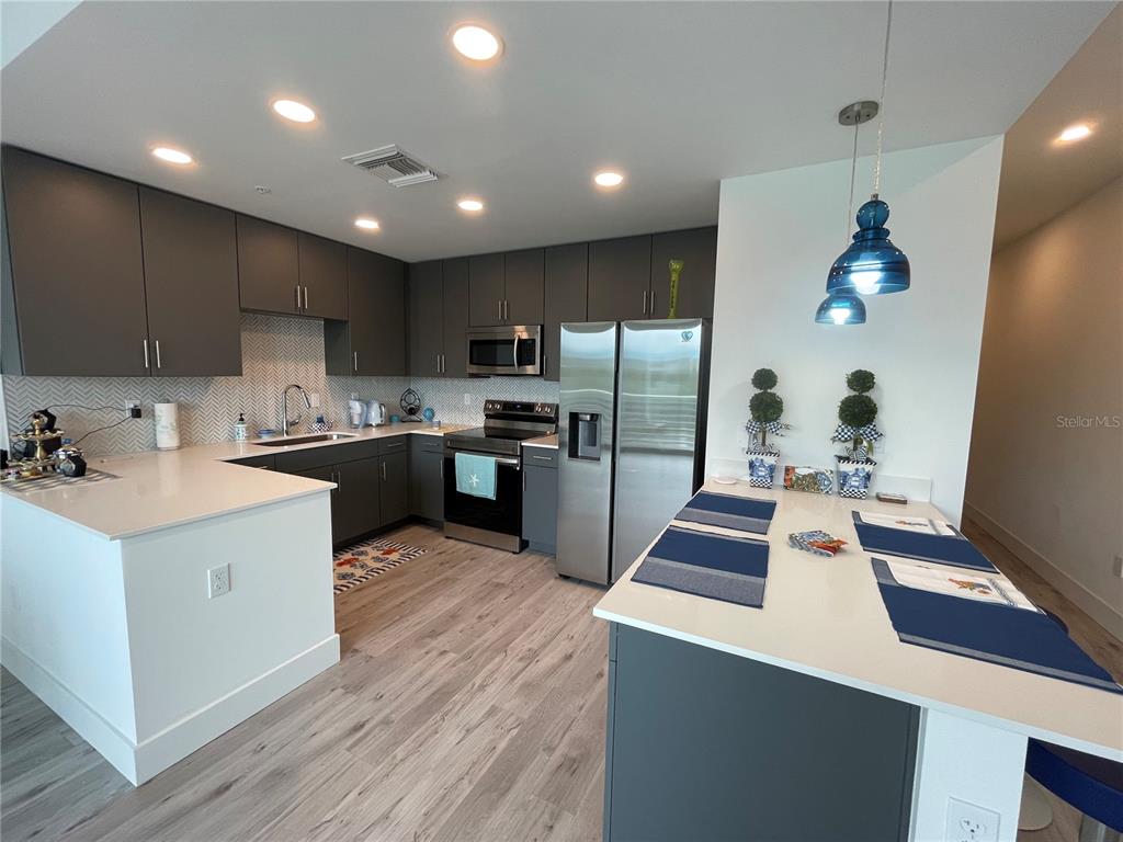 1709 North Tamiami Trail, Unit 213 Sarasota, FL 34234 - Photo 11 of 49 a kitchen with kitchen island white cabinets and stainless steel appliances