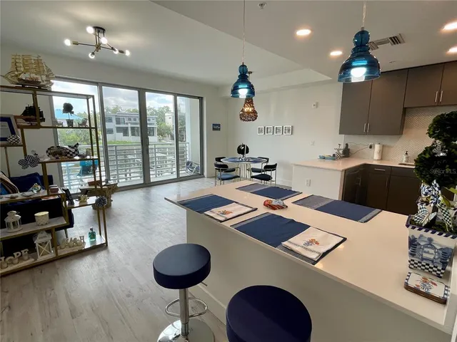 a kitchen with a table chairs a stove and a view of living room