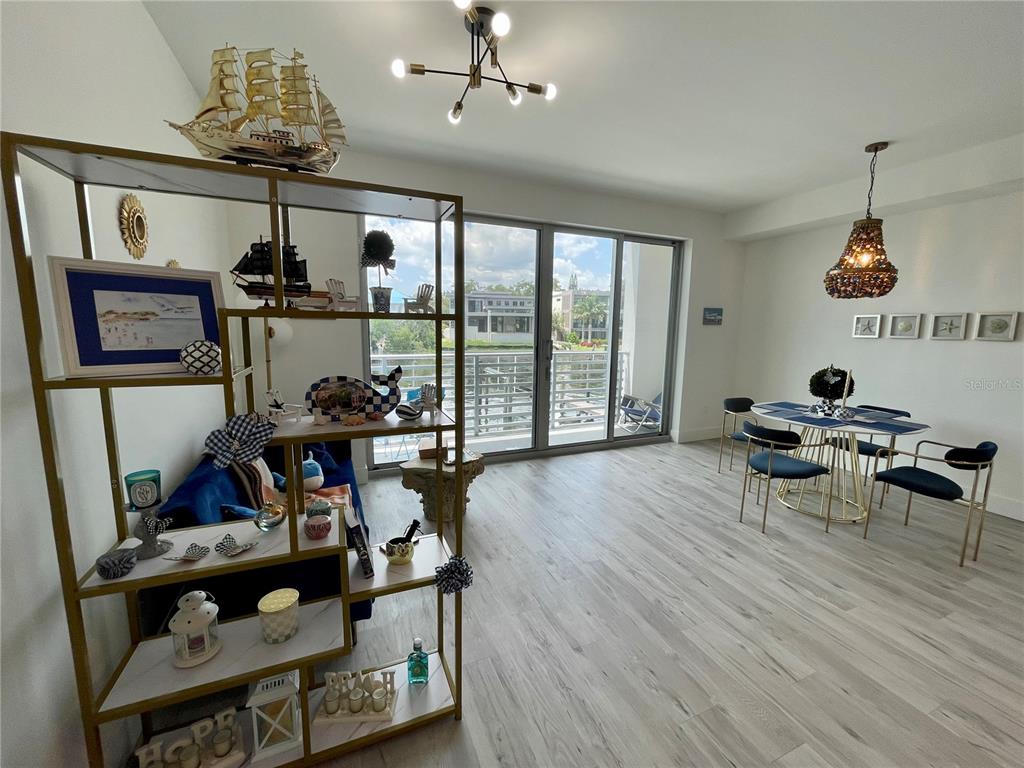 1709 North Tamiami Trail, Unit 213 Sarasota, FL 34234 - Photo 14 of 49 a view of a dining room with furniture wooden floor and chandelier