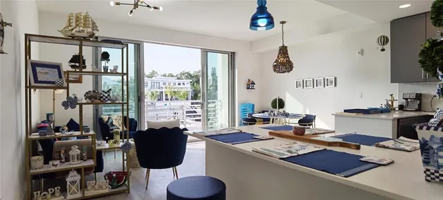 a living room with dining table and a floor to ceiling window