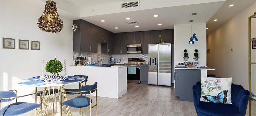 1709 North Tamiami Trail, Unit 213 Sarasota, FL 34234 - Photo 37 of 49 a kitchen with a refrigerator and a dining table