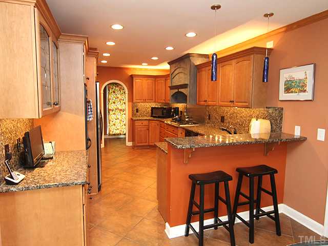 8644 Valley Brook Drive Raleigh, NC 27613 - Photo 3 of 18 KITCHEN: Nice eat in bar in the kitchen and through the archway is an office and/or butlers pantry with ganite counter and a wine refrigerator!