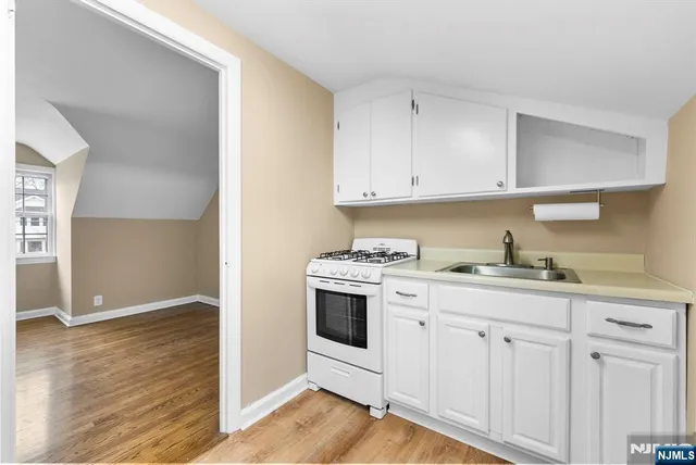 a kitchen with granite countertop white cabinets and white appliances