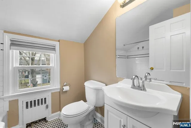 a bathroom with a sink a toilet and a window