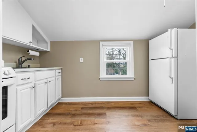 a kitchen with white cabinets and white appliances
