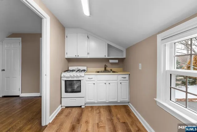 a kitchen with granite countertop white cabinets and white appliances