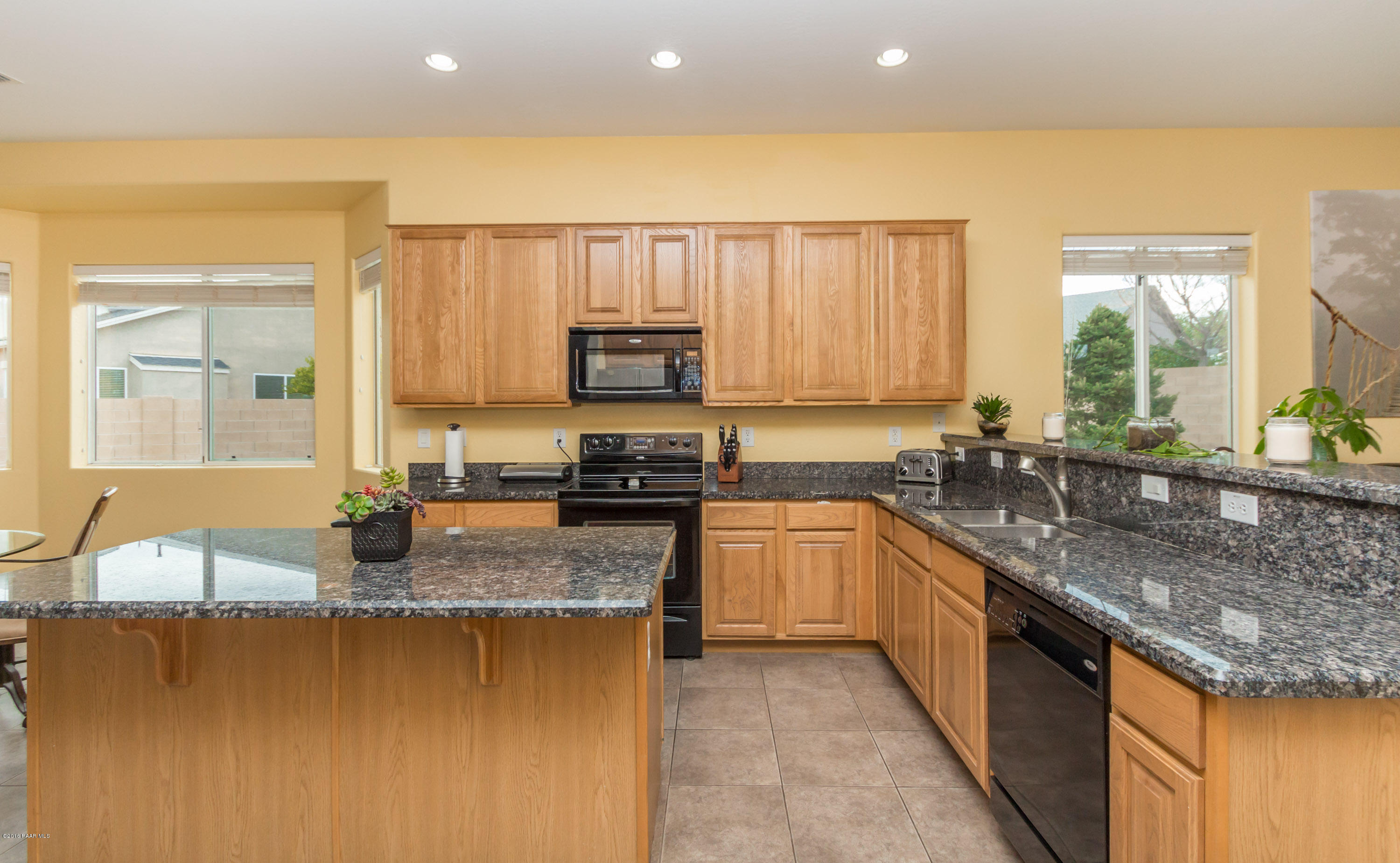 7887 East Mesteno Road Prescott Valley, AZ 86315 - Photo 11 of 30 a kitchen with stainless steel appliances granite countertop a sink a stove top oven a counter space and cabinets