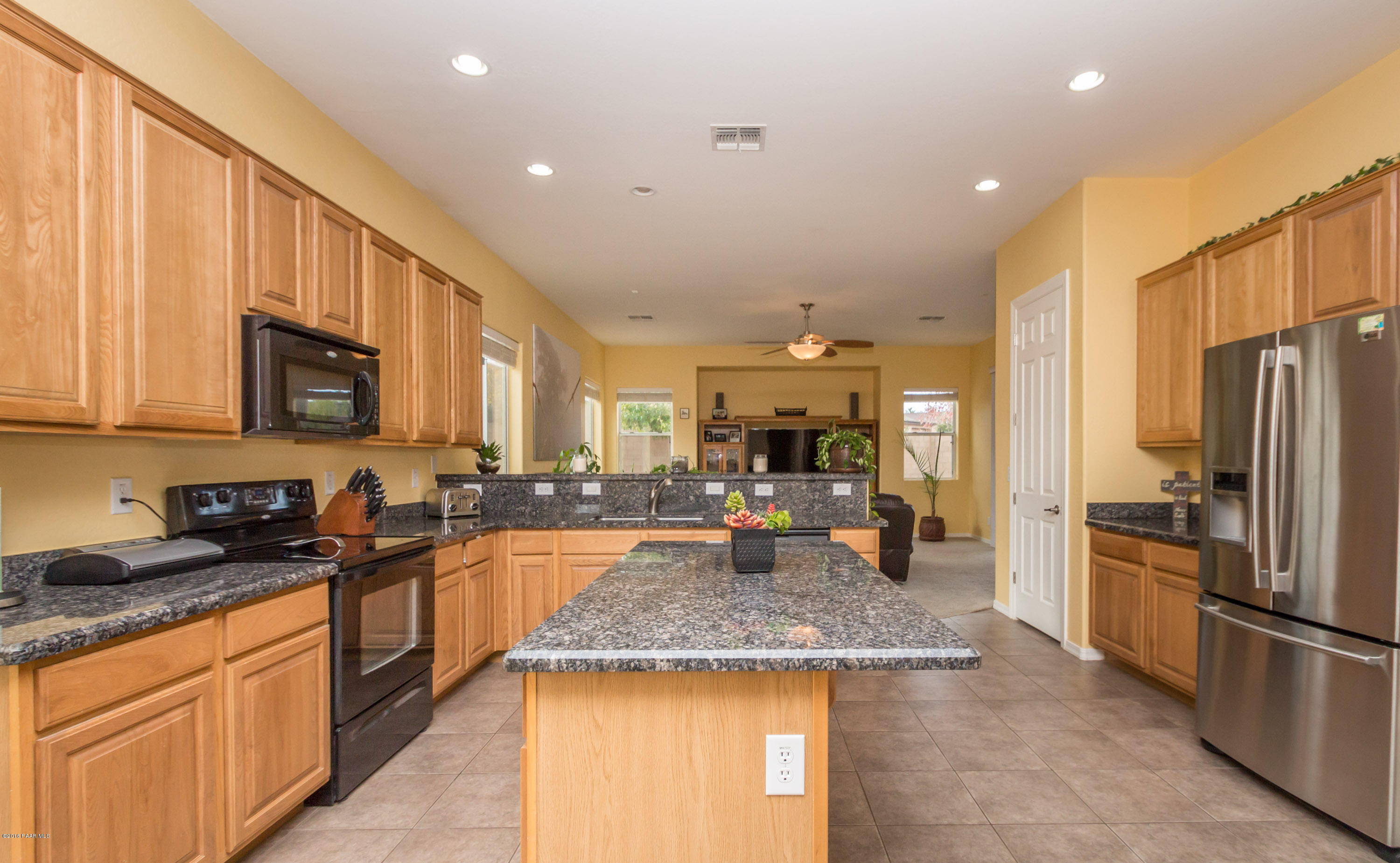 7887 East Mesteno Road Prescott Valley, AZ 86315 - Photo 12 of 30 a kitchen with stainless steel appliances granite countertop a sink stove and refrigerator