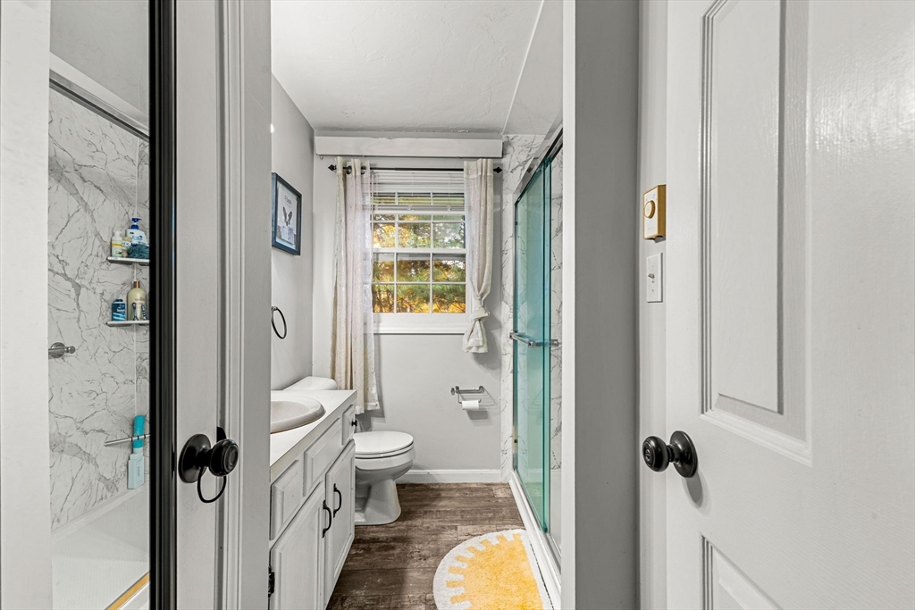 23 Magnolia Street, Unit 2 Attleboro, MA 02703 - Photo 20 of 32 a bathroom with a granite countertop toilet a sink a mirror and a shower