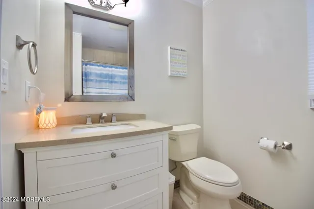 a bathroom with a granite countertop toilet sink and mirror