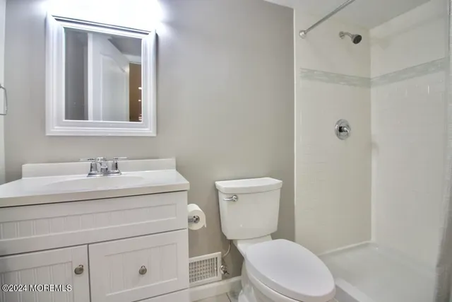 a bathroom with a toilet a sink a vanity and mirror
