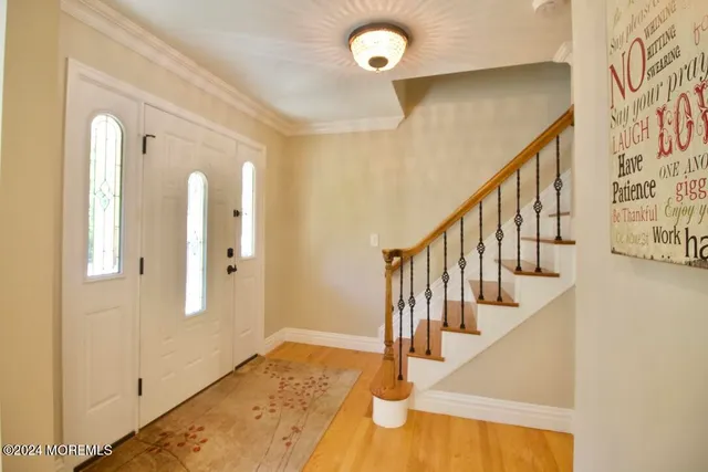 a view of staircase with lots of frames on wall and a chandelier