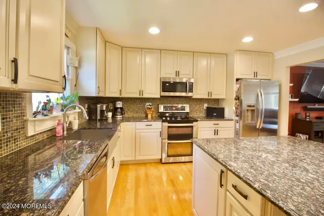 a kitchen with stainless steel appliances granite countertop a stove top oven a sink and dishwasher
