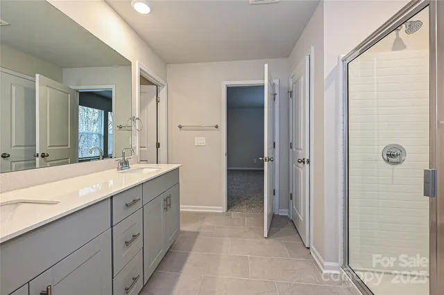 a spacious bathroom with a granite countertop sink a mirror and a shower