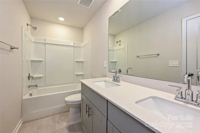 a bathroom with a granite countertop sink a toilet and shower